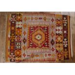 Kelim rug with bright green geometric designs around a central panel, 190cm x 134cm (approx)Wear and