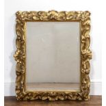 Baroque carved giltwood frame 18th Century, with foliate scroll decoration and later mirror inset