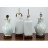 Two pairs of Chinese style table lamps one with green flowers and branches on a white ground, on