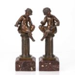 Pair of spelter cherubs representing the Arts late 19th Century, each seated on a column and with