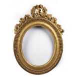 A late 18th century French oval giltwood frame with ribbon bow and foliate cresting, egg and dart