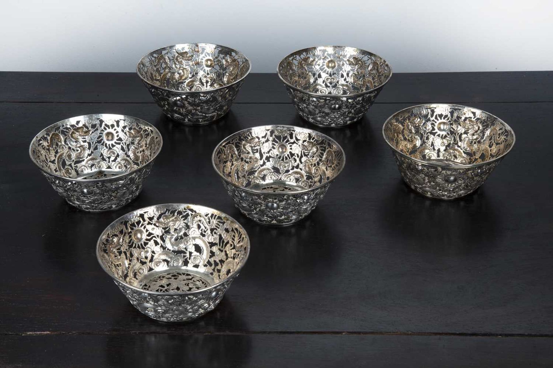 Set of six white metal/silver openwork bowls Chinese, circa 1900 each decorated with dragons chasing