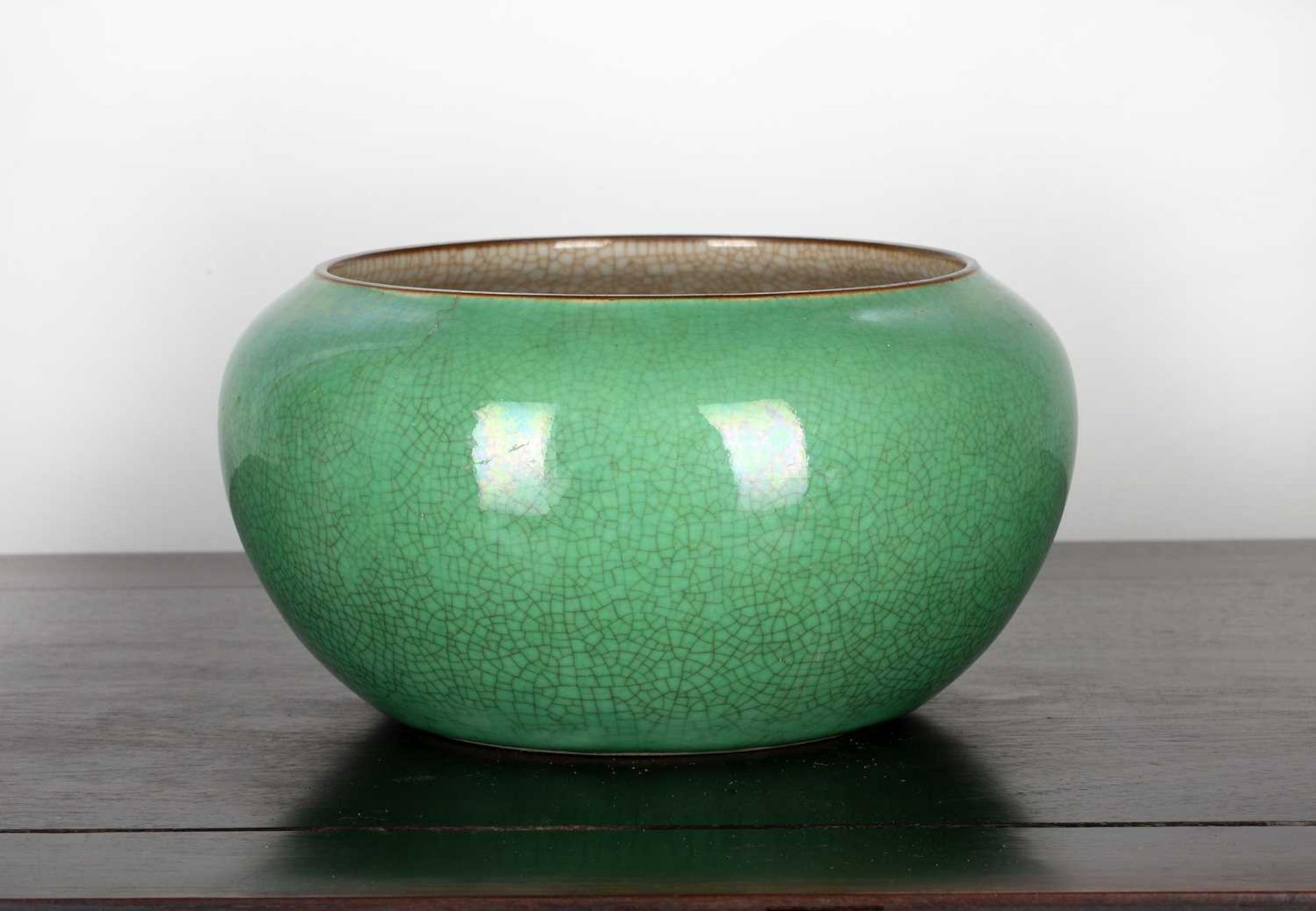 Large green porcelain bowl Chinese, 19th Century with all over crazing and cafe au lait rim, 26cm