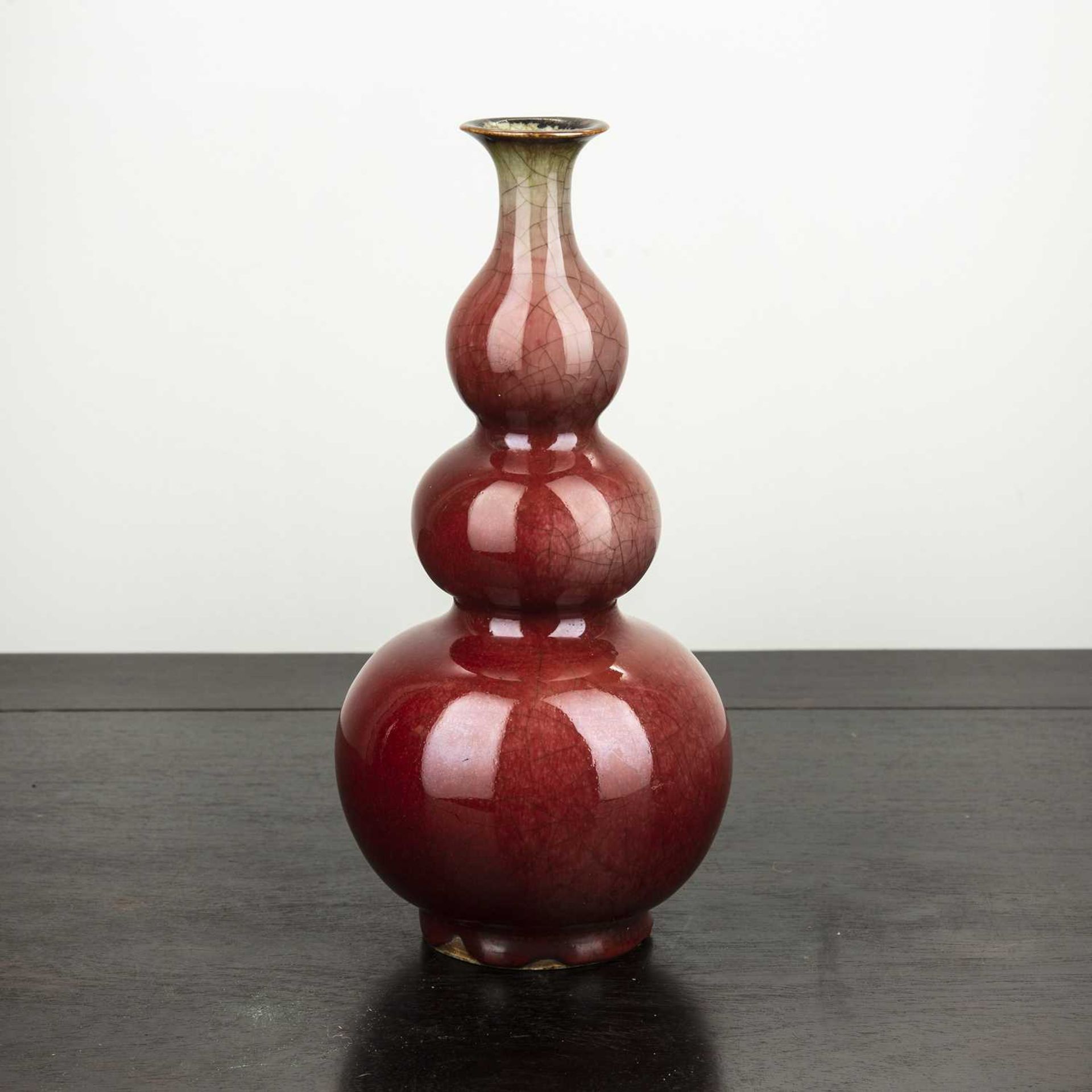 Triple gourd vase Chinese, late 19th Century covered all over with a deep red glaze, 24cm high