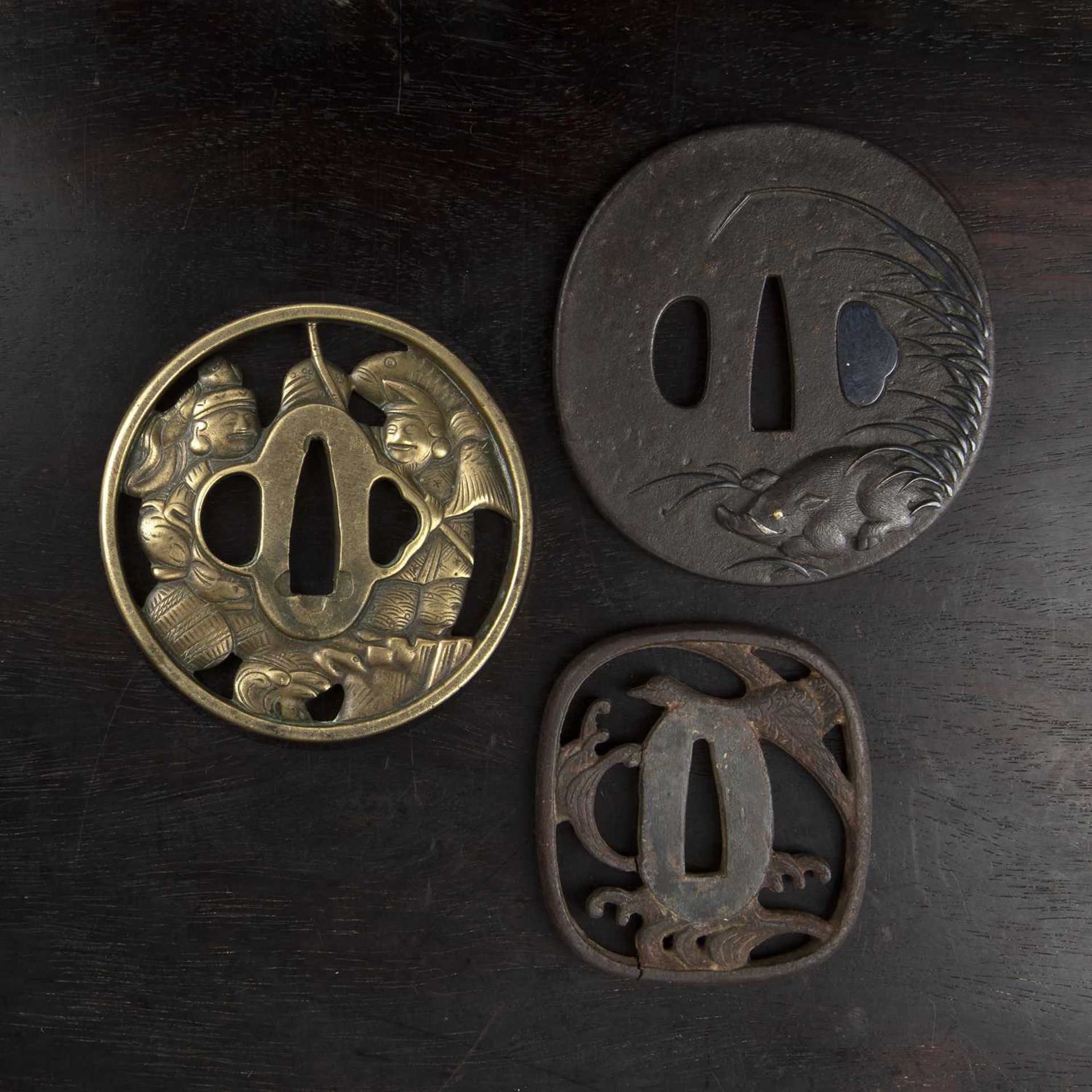 Three tsubas Japanese, 18th/19th Century to include a sentoku tsuba depicting two figures from