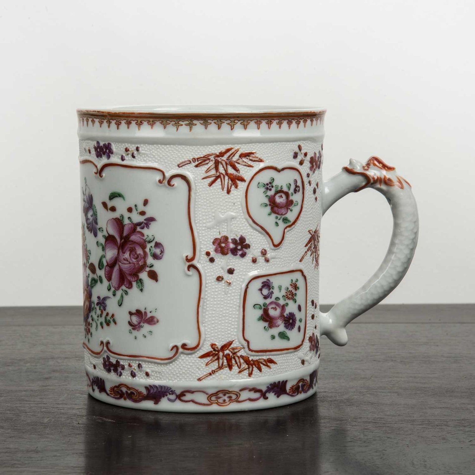 Famille rose tankard Chinese with raised decoration, with panels of flowers, the handle stylised