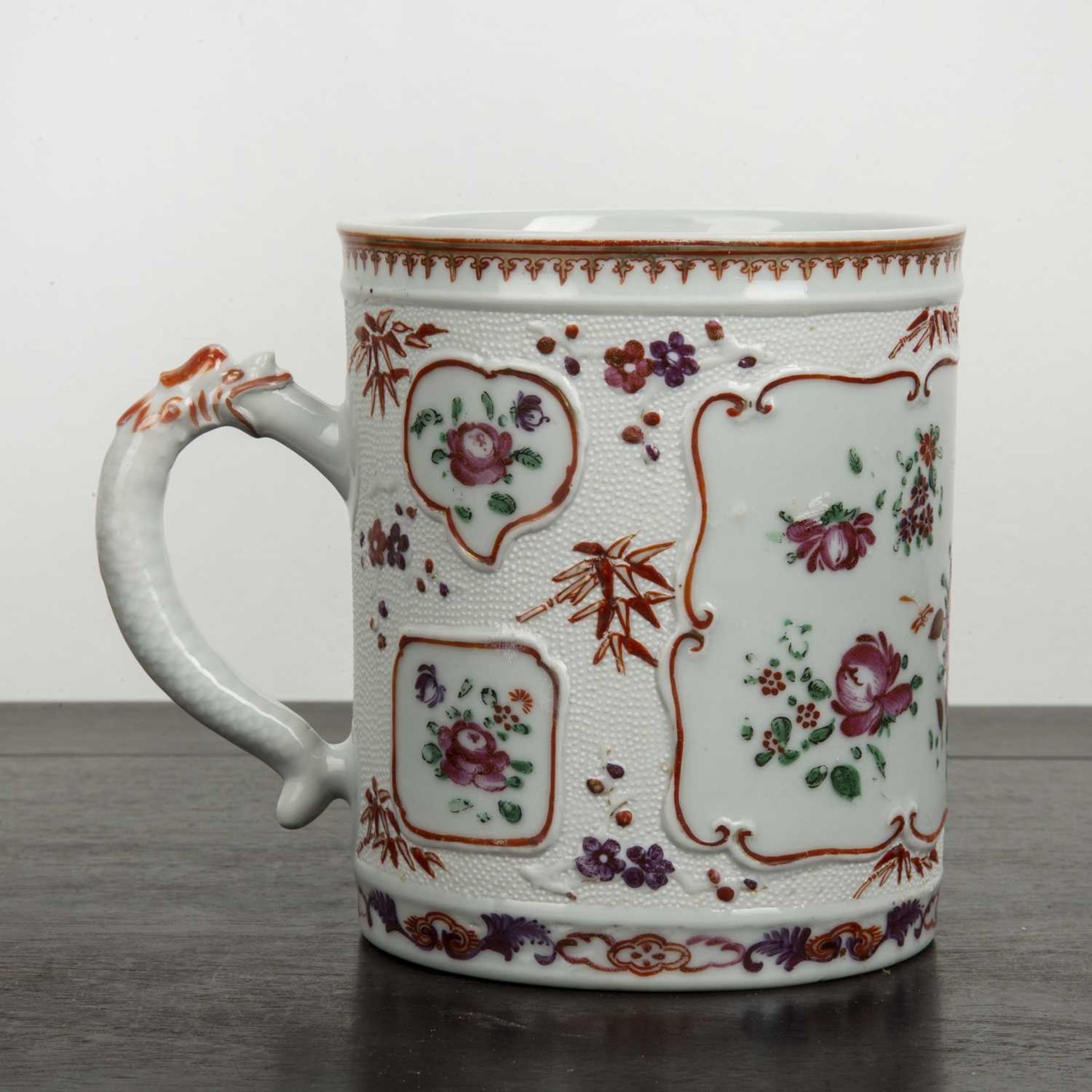 Famille rose tankard Chinese with raised decoration, with panels of flowers, the handle stylised - Image 3 of 5