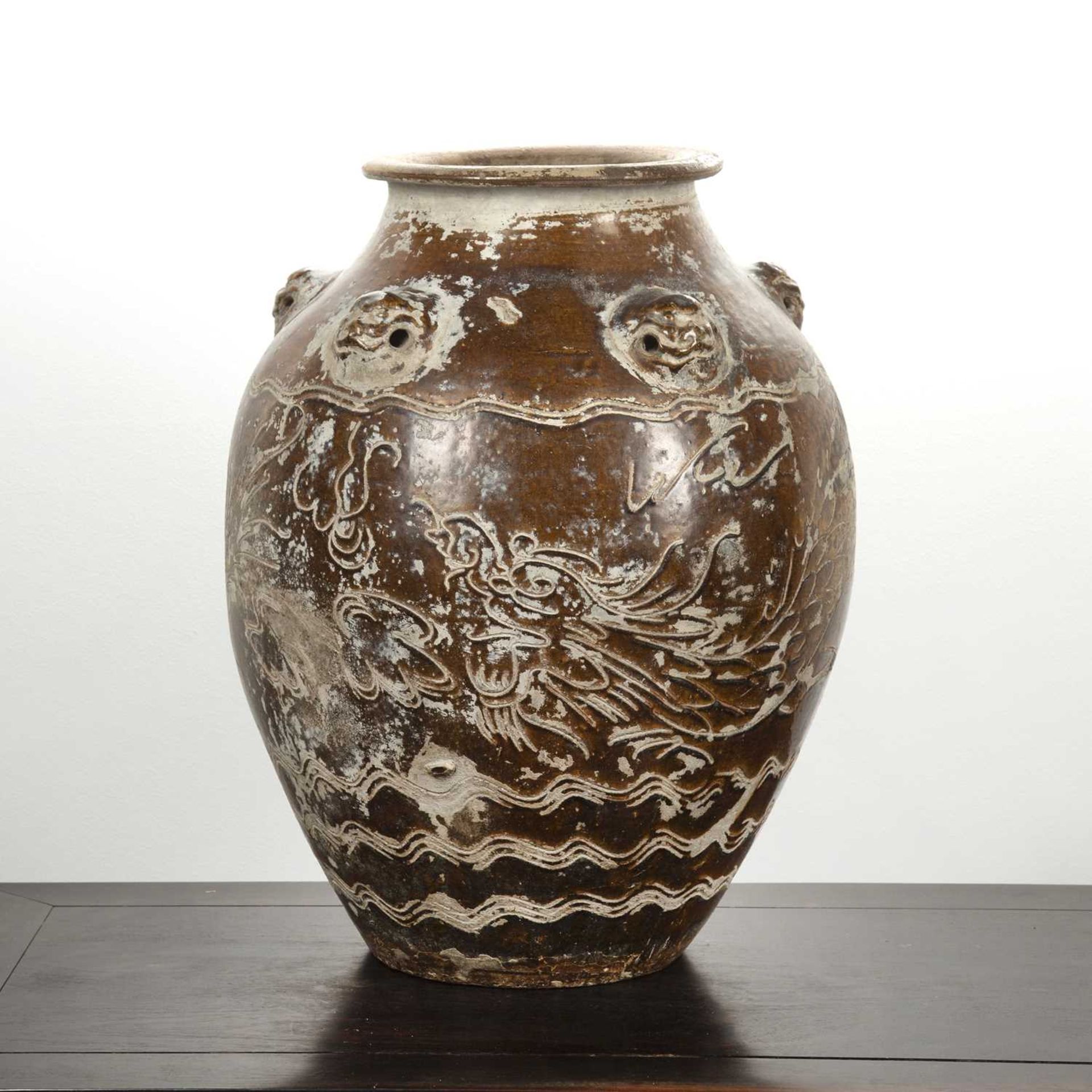 Large treacle glazed storage jar Chinese, 17th/18th Century having five mask handles around the