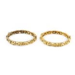 A pair of yellow precious metal bangles, of hinged circular form, with repeating foliate motifs,