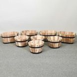 A set of four coopered wooden garden planters