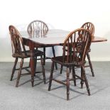 A set of four wheel back dining chairs