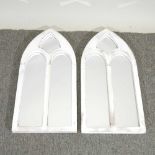 A pair of white framed wall mirrors