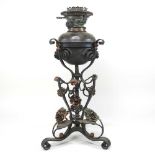 An Arts and Crafts wrought iron oil lamp