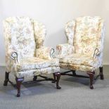 A pair of Georgian style wing armchairs