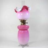 A pink glass oil lamp and shade