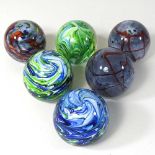 A set of six coloured glass paperweights