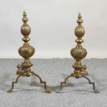 A pair of brass fire dogs