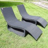 A pair of rattan sun loungers