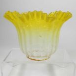 A small yellow glass oil lamp shade