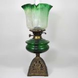 A green glass and cast iron oil lamp