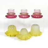 A set of three cranberry glass shades