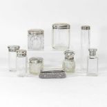A collection of silver top dressing table jars