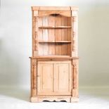 An antique pine corner cupboard