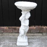 A cast stone bird bath