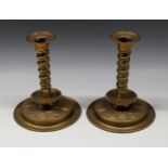 A pair of 18th century Dutch style brass candlesticks with barleytwist stems, basal drip pan