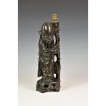 A Chinese carved hardwood figure of Shou Lao with inset glass eyes and bone teeth,