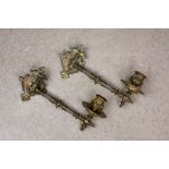 A pair of ornate Victorian bronze pivoted candle wall sconces with shaped and decorated back