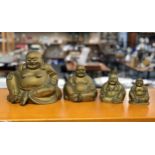 A matched graduated set of four Chinese brass smiling Buddha figures