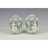 A pair of French pate-sur-pate plaques c.1900, oval with anthemion, floral and foliate cresting,