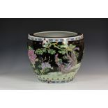 A Chinese porcelain black ground famille rose fish bowl, second half 20th century, painted in
