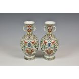 A pair of Chinese enamel vases having twin mask and tongue handles to elongated neck,