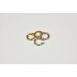 Two pairs of loop twist 9ct gold earrings one in yellow gold, the other pair in white gold, weight