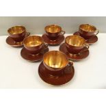 A set of six Jersey Pottery coffee cups and saucers with chocolate brown glaze