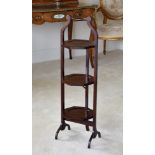 A mahogany three tier folding cake stand, 1920s, with dished octagonal tiers and turned top