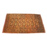 A Tekke Bokhara rug, 20th century, the burnt orange field with two rows of seven dark blue gols,