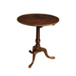 A George III mahogany tilt top tripod table, the dished top on a turned gun barrel column to three