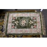 A small Chinese silk rug, late 20th century, the central sage green field with floral decoration,
