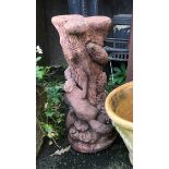 A composite stone garden ornament in the form of an ivy covered tree with two squirrels meeting,