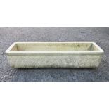 A composite stone planter by Grandon Fres France, 27¼ x 7¾in. (69.2 x 19.6cm.), 6in. (15.2cm.) high.