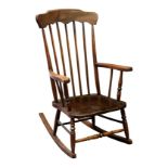 A beech and elm stick back Windsor rocking chair, early 20th century.