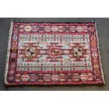 A small Turkoman rug, the field with three hooked medallions, stylised animals, insects and trees,