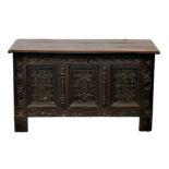 A late 17th century carved and inlaid oak coffer, the three plank top on original hinges, over