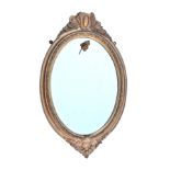 A Victorian gilt and composition oval mirror, with bevelled plate, the shot and curled ribbon