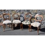 A matched set of four Victorian carved walnut balloon back chairs. (4),