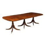 A George III style mahogany triple pillar dining table, early 20th century, the top with rounded