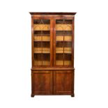 An early Victorian mahogany library bookcase, the ogee flared cornice over a pair of lancet 9 pane